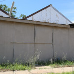 Unpainted, unsecured and falling down fibro sheeting on a garage / shed.