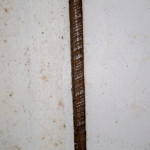 Asbestos lagging around pipe under kitchen sink.