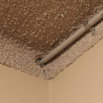 Vermiculite "popcorn" ceiling with electrical conduit